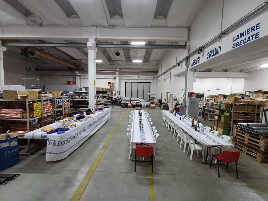 Interno della fabbrica con tavole apparecchiate per una cena di lavoro